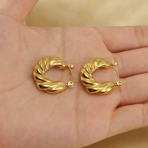 Fashionable 18K gold-plated stainless steel hoop earrings with twisted texture in hand