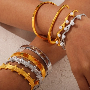 Elegant 18k gold and silver titanium steel bracelets set with pearls shown on wrists