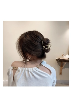 Close-up of golden metal floral hair claw clip on elegant back view hairstyle