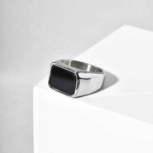 Detailed close-up of a geometric stainless steel ring with a rectangular black stone inlay