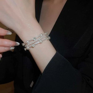 Detail of multi-layer layered bracelet with white pearls and sparkling zircon accents