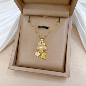 Detail of flower necklace with white pearls and green enamel in a luxury jewelry box