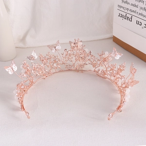 Detail of rose gold bridal crown with butterfly ornaments and white flower accents