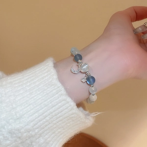 Detail of beaded moon and star bracelet with blue frosted beads and silver zircon pendant