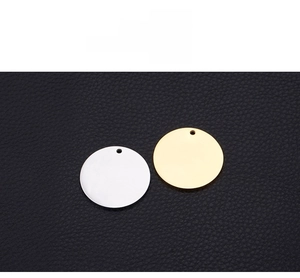 Close-up of polished gold and silver circular pendants on a black leather background