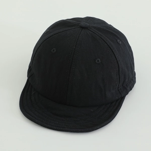 Detailed view of the soft short brim and breathable stitching on this black kids' cap