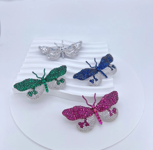 Détail de broches papillon de luxe avec incrustation de zircon sur support blanc