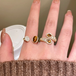 Detail of tiger eye stone and zircon rings set on hand with French vintage luxury style