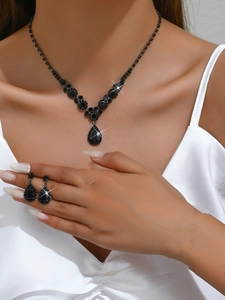 Close-up of black teardrop rhinestone bridal necklace and earrings set worn by a model