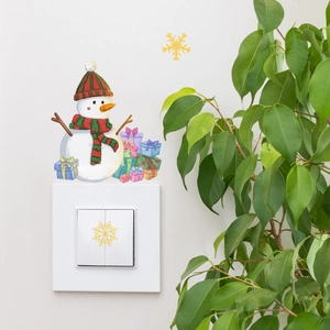 Glow-in-the-dark snowman wall sticker with colorful gifts and snowflakes around light switch