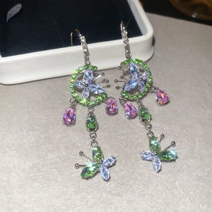 Detail of colorful floral butterfly earrings with sparkling crystals and metal tassels