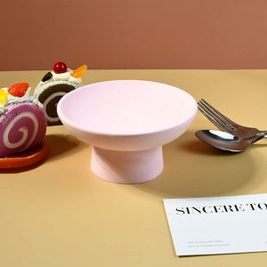 Dettaglio di ciotola in ceramica rosa opaca con piedistallo per dessert e decoro