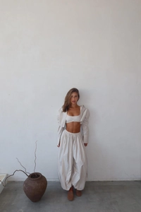 Detailed texture of beige three-piece lounge set with cropped top and lantern pants