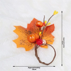 Detail of maple leaf and pumpkin napkin ring with autumn berries for Thanksgiving decor