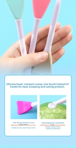 Dual-head silicone face mask brush detail showing flat brush head and small scoop tool