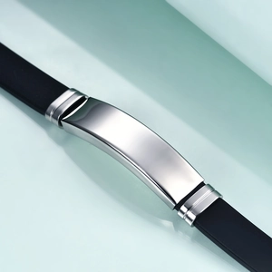 Macro detail of polished stainless steel curved plate on black silicone wristband