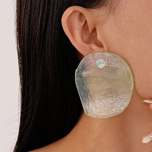Close-up of translucent light green irregular resin earrings with wrinkled texture on model