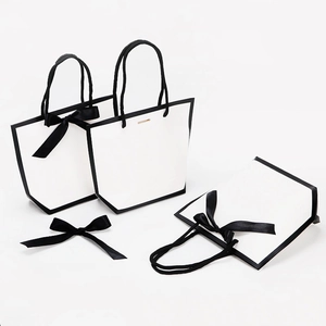 Minimalist white gift paper bag with black trim and elegant ribbon handle for boutiques
