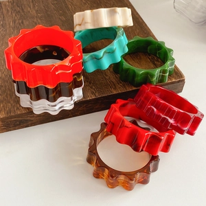 Macro view of colorful resin chunky bangles with unique gear-shaped wavy edges