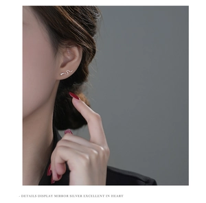 Close-up of minimalist S925 silver snake earring worn by a model with mirror finish