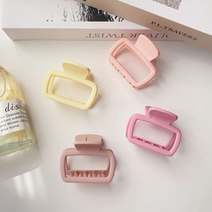 Set of four matte rectangular claw clips in pastel pink and yellow for elegant hair styling