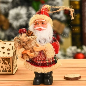 Standing Santa Claus doll in red plaid fabric on a wooden table with festive background