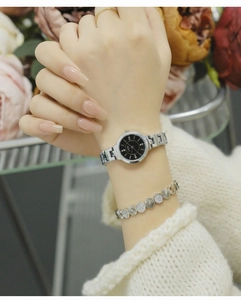 Elegant women's silver alloy watch with black dial and rhinestones on female wrist