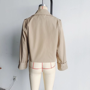 Vue arrière du trench-coat court beige à double boutonnage montrant la texture du tissu