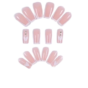 Faux ongles French blancs classiques avec base rose motifs de cœurs et petits strass