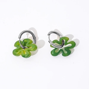 Detail of green acrylic flower earrings with silver hoops on white background