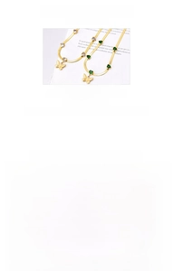 Detail of titanium gold necklace featuring butterfly pendant and green cubic zirconia