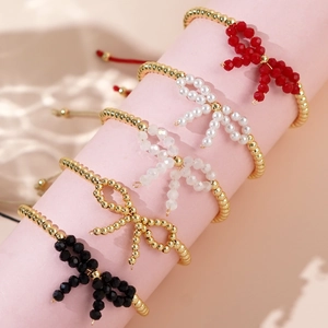 Cinque braccialetti a fiocco placcati oro 18K con perle e cristalli su supporto rosa
