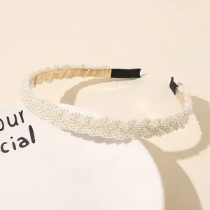 Detailed view of pearl headband with white imitation pearls on metal base and end guards