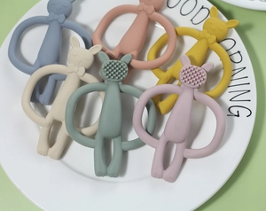 Detailed view of colorful silicone bunny teethers with various textures on a white plate