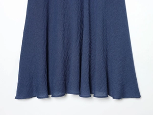 Dettaglio dell'orlo del vestito midi blu testurizzato che mostra il tessuto e il drappeggio