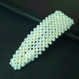 Detailed view of handmade rectangular pearl hair clip with gold metal base and white beads