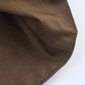 Macro detail of brown cotton poplin fabric texture and fine stitching on the shirt dress