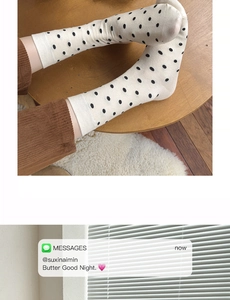 Detail von weißen Baumwollsocken mit schwarzen Punkten und süßem Cartoon Hundemuster