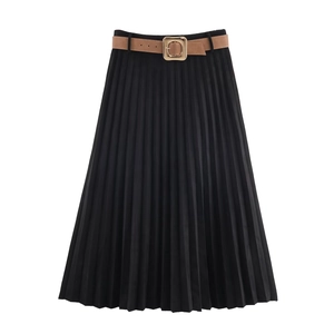 Détail d'une jupe midi plissée noire avec ceinture en cuir marron et boucle dorée