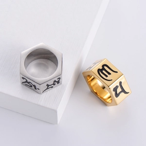Detail of silver and gold hexagonal nut rings with engraved Sanskrit symbols