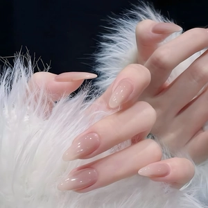 Unghie finte a mandorla lunghe rosa nude effetto jelly con glitter su sfondo di piume bianche