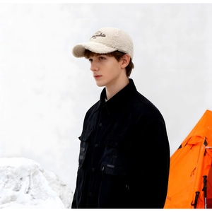 Gros plan sur une casquette en laine d'agneau beige avec broderie de lettres marron