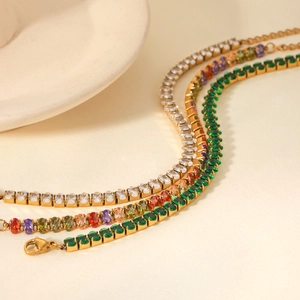 Macro detail of gold tennis bracelets with colorful zircon stones and lobster clasp