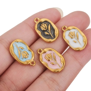 Detail of colorful enamel rose pendants with gold borders on stainless steel charms