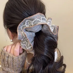 Oversized retro blue checkered scrunchie with white lace trim for hair styling