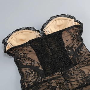 Dettaglio del corpetto in pizzo nero con fodera color nudo e ricami floreali