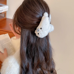 Detail showing plush white seal hair claw clip on model's hair with a cozy back view