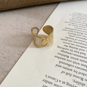 Detail view of warm gold ring with hammered texture on vintage book background