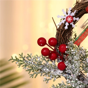 Macro detail of Christmas wreath with red berries, pine branches and snowy decorations