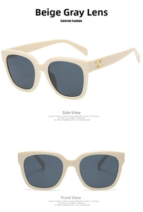 Detail of beige square sunglasses with dark grey lenses and gold metal trim on temples